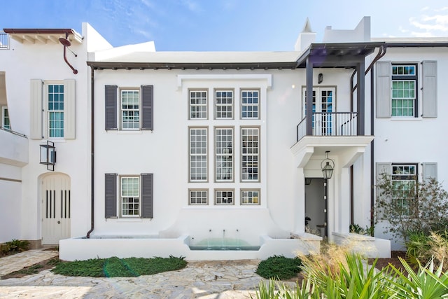 view of front facade featuring a balcony and stucco siding