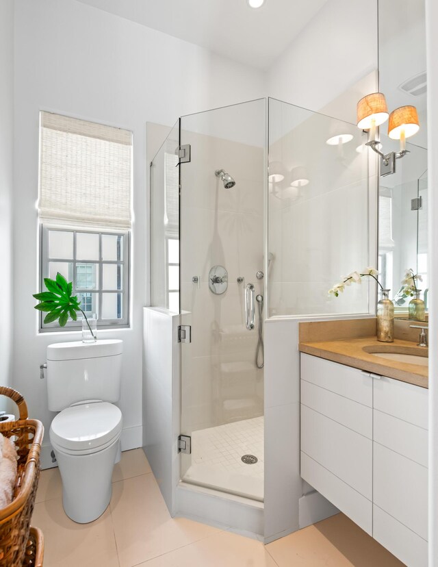 bathroom with tile patterned flooring, a shower stall, vanity, and toilet