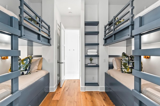 interior space featuring open shelves, light wood-type flooring, and baseboards