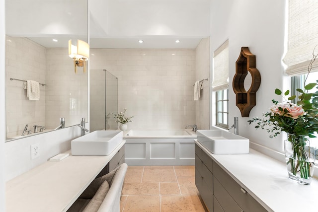 bathroom with vanity, a garden tub, and recessed lighting