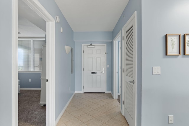 hallway with light tile patterned flooring and baseboards