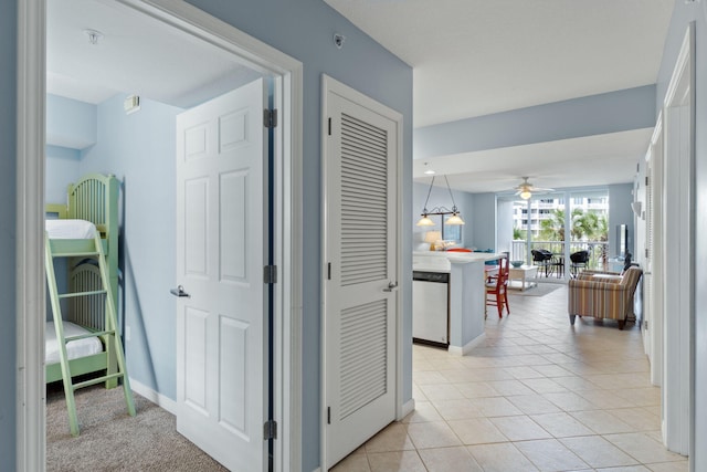 hallway featuring baseboards and light tile patterned flooring