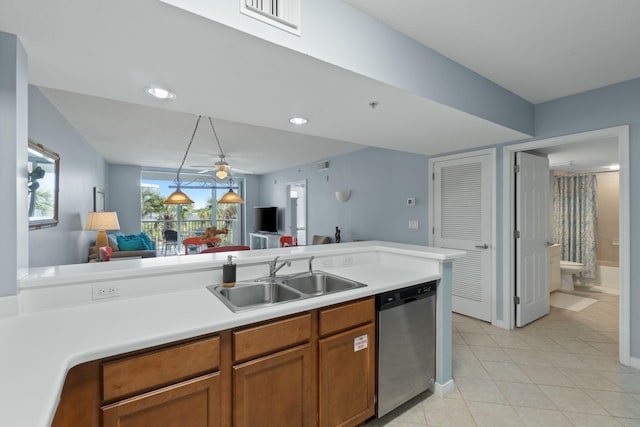 kitchen with light tile patterned floors, a sink, light countertops, dishwasher, and brown cabinets