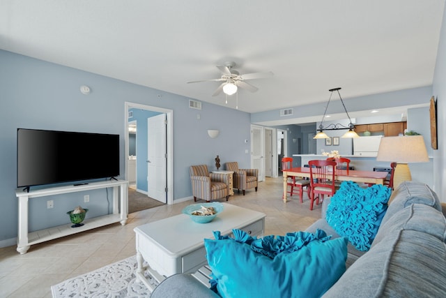 living room with a ceiling fan, light tile patterned flooring, baseboards, and visible vents