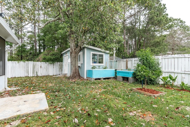 1634 N Campbell Dr, Fort Walton Beach, FL 32547 - view of yard with an outdoor structure, a fenced backyard, a garden, and a storage unit