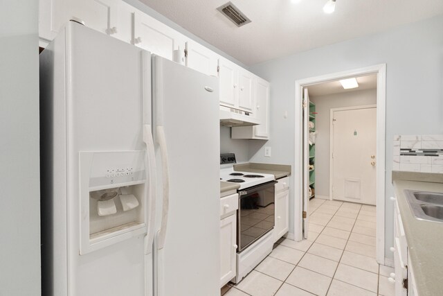 1634 N Campbell Dr, Fort Walton Beach, FL 32547 - kitchen with visible vents, light tile patterned flooring, white appliances, white cabinetry, and under cabinet range hood