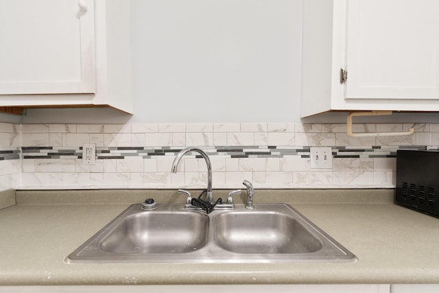 1634 N Campbell Dr, Fort Walton Beach, FL 32547 - kitchen featuring a sink, backsplash, and white cabinetry