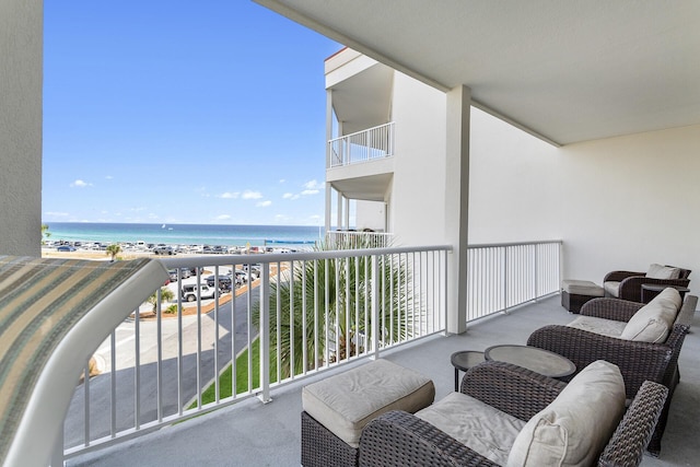 balcony featuring a beach view and a water view