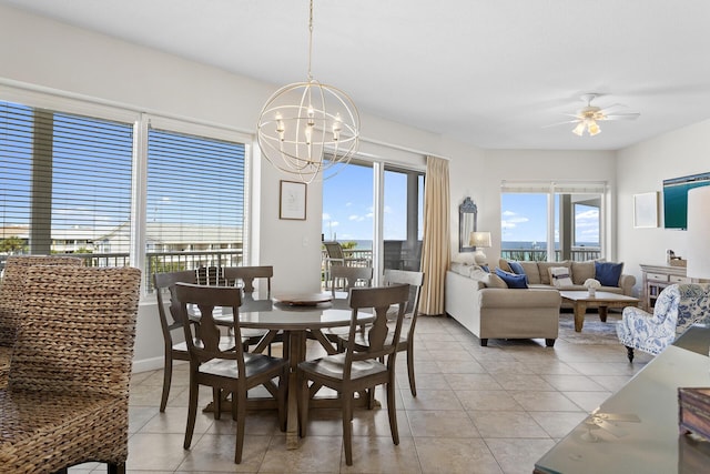 dining area featuring light tile patterned floors, ceiling fan with notable chandelier, and baseboards