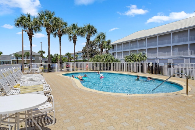 pool with a patio and fence