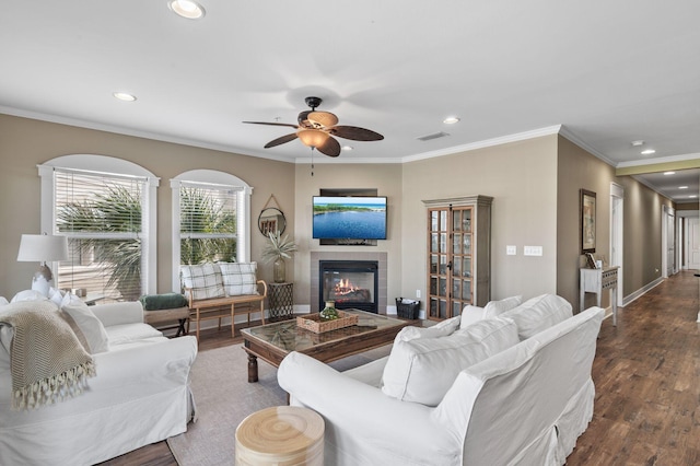 living room with dark wood-type flooring, recessed lighting, visible vents, and a tile fireplace