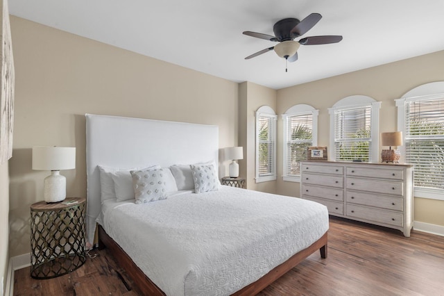 bedroom featuring ceiling fan, baseboards, and wood finished floors