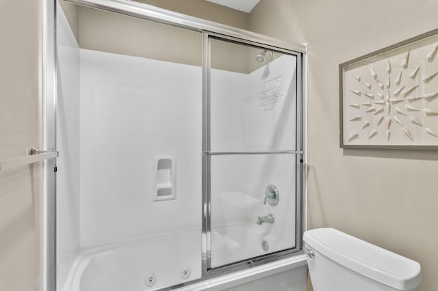 bathroom featuring enclosed tub / shower combo and toilet