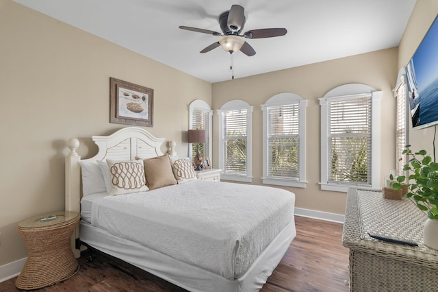 bedroom featuring ceiling fan, baseboards, and dark wood finished floors