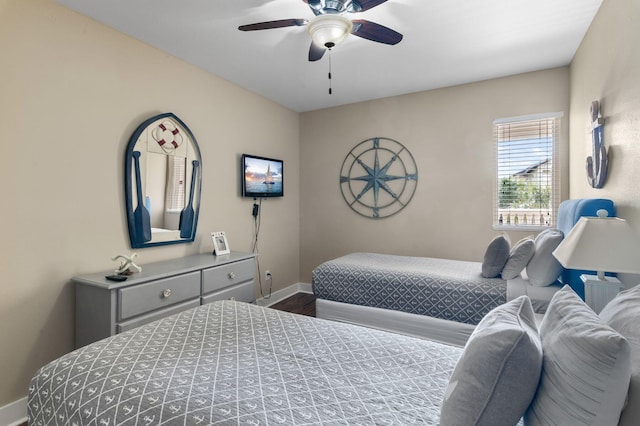 bedroom featuring ceiling fan, baseboards, and dark wood-style flooring