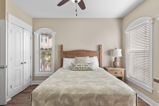 bedroom featuring baseboards, dark wood-style flooring, and a closet