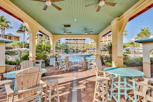 view of patio with ceiling fan, visible vents, outdoor dining space, and fence