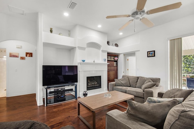 living room featuring visible vents, baseboards, recessed lighting, a fireplace, and wood finished floors