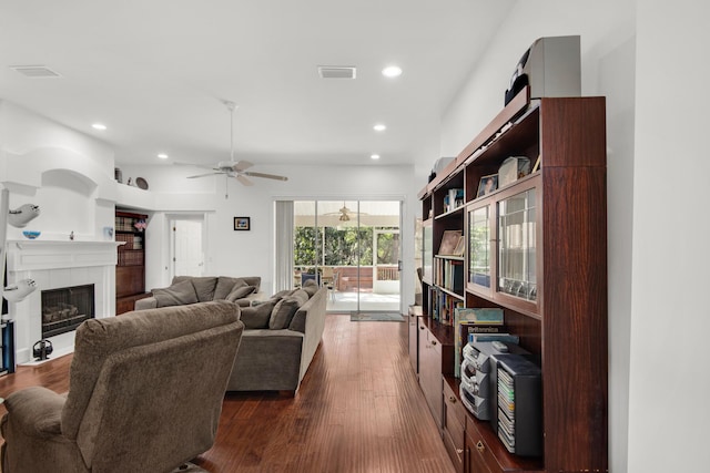 living area featuring a ceiling fan, recessed lighting, dark wood-style flooring, and a tile fireplace