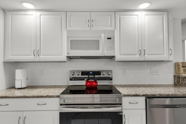 kitchen with backsplash, appliances with stainless steel finishes, and white cabinetry