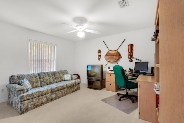 office space with light carpet, visible vents, and ceiling fan