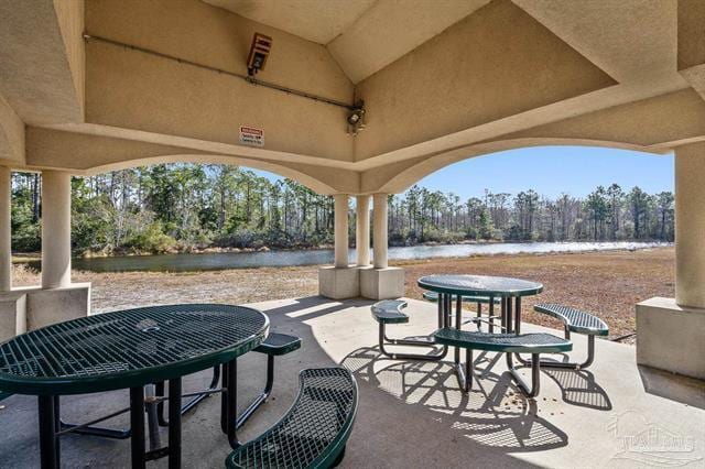 1607 Woodlawn Way, Gulf Breeze, FL 32563 - view of patio featuring a water view, outdoor dining space, and view of scattered trees