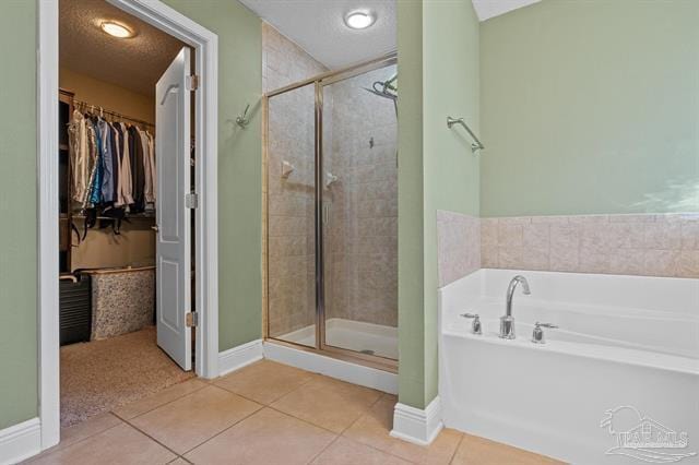 1607 Woodlawn Way, Gulf Breeze, FL 32563 - bathroom featuring a bath, a stall shower, tile patterned floors, and a spacious closet