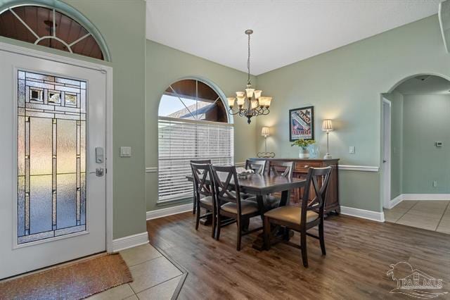 1607 Woodlawn Way, Gulf Breeze, FL 32563 - dining room featuring plenty of natural light, arched walkways, a chandelier, and wood finished floors