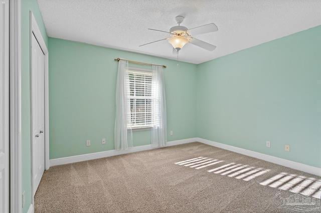 1607 Woodlawn Way, Gulf Breeze, FL 32563 - unfurnished bedroom featuring carpet flooring, a closet, a textured ceiling, and ceiling fan