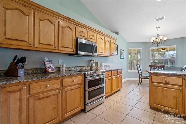 1607 Woodlawn Way, Gulf Breeze, FL 32563 - kitchen featuring appliances with stainless steel finishes, vaulted ceiling, a chandelier, light tile patterned flooring, and brown cabinets