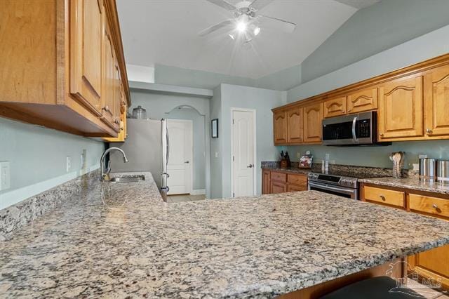 1607 Woodlawn Way, Gulf Breeze, FL 32563 - kitchen with appliances with stainless steel finishes, light stone countertops, ceiling fan, a peninsula, and lofted ceiling