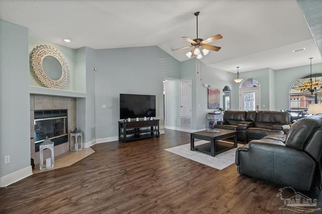1607 Woodlawn Way, Gulf Breeze, FL 32563 - living room featuring wood finished floors, a tiled fireplace, ceiling fan, high vaulted ceiling, and a chandelier