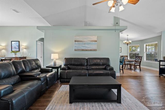 1607 Woodlawn Way, Gulf Breeze, FL 32563 - living area featuring wood finished floors, ceiling fan, lofted ceiling, a chandelier, and arched walkways