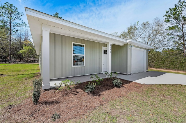 view of front facade with a garage, concrete driveway, and a front lawn