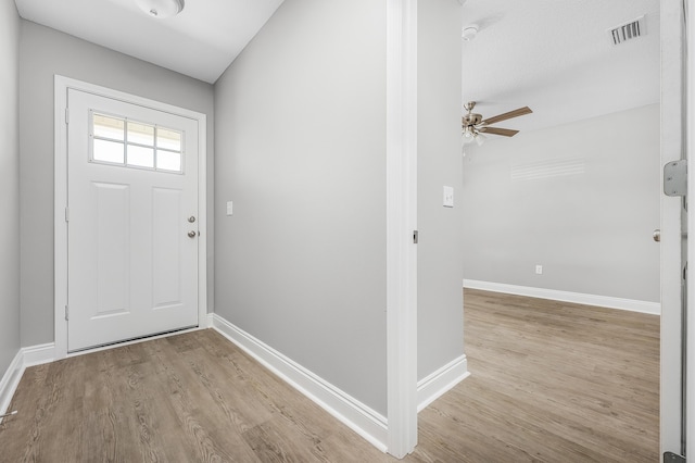 entrance foyer featuring visible vents, baseboards, light wood-style floors, and a ceiling fan