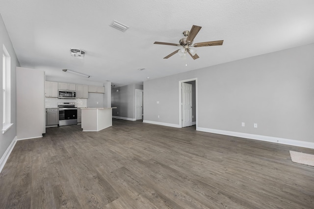 unfurnished living room with visible vents, baseboards, a ceiling fan, and dark wood-style flooring