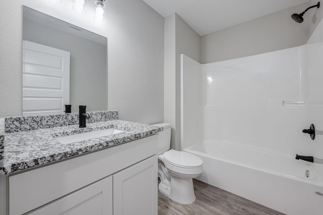 full bathroom featuring shower / washtub combination, toilet, vanity, and wood finished floors