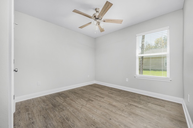 empty room with ceiling fan, baseboards, and wood finished floors