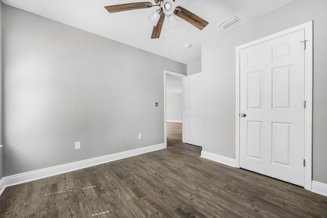 unfurnished bedroom featuring visible vents, a ceiling fan, baseboards, and dark wood-style flooring