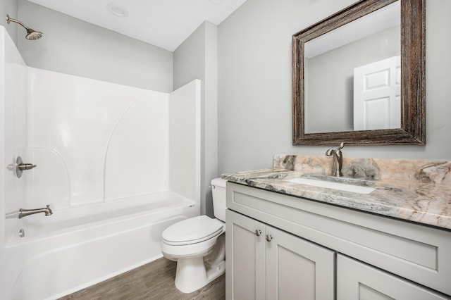 bathroom with vanity, shower / tub combination, toilet, and wood finished floors