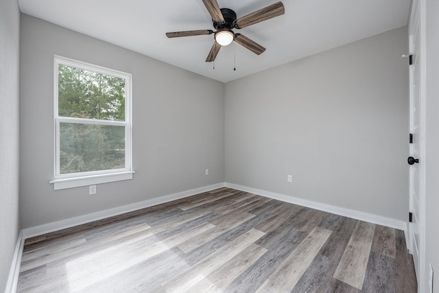 unfurnished room with a ceiling fan, wood finished floors, and baseboards