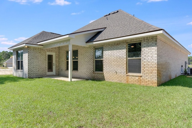 back of house featuring brick siding, a patio area, and a lawn