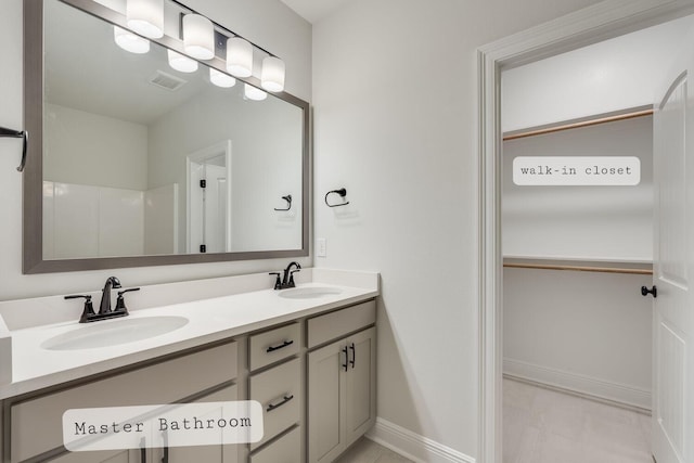 full bathroom with a sink, visible vents, baseboards, and double vanity