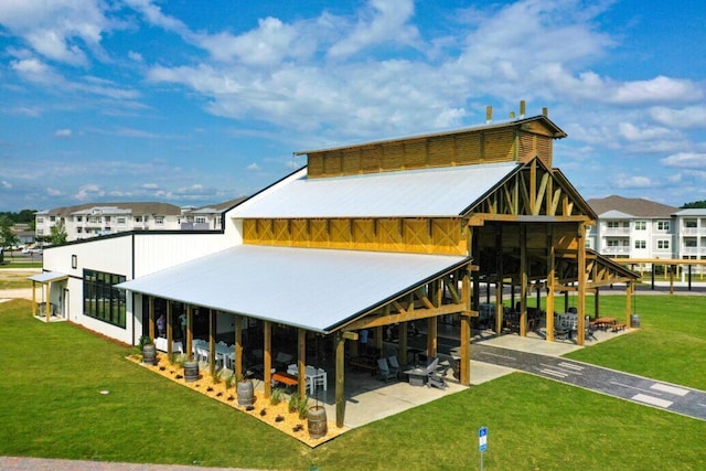 back of property with a patio area, metal roof, and a yard