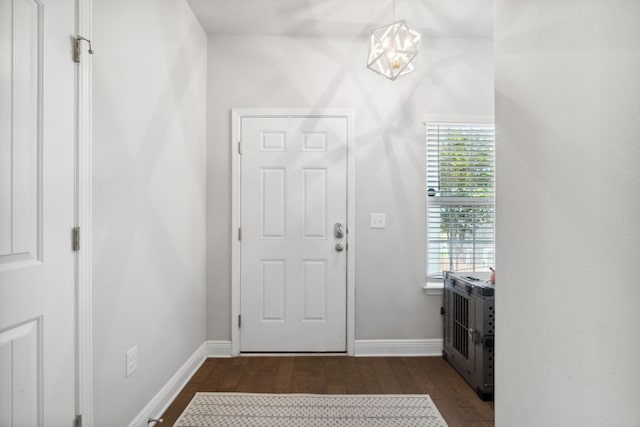 foyer with dark wood-style floors and baseboards