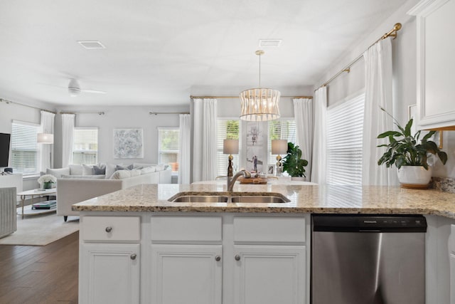 kitchen with open floor plan, dark wood-style flooring, stainless steel dishwasher, white cabinetry, and a sink