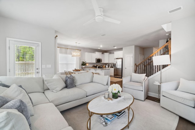 living room with visible vents, baseboards, ceiling fan, stairway, and recessed lighting