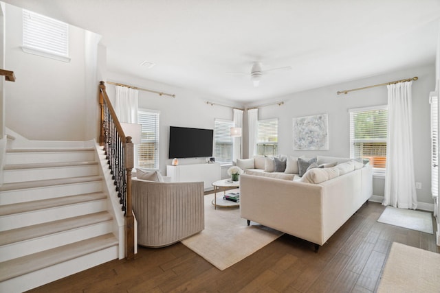 living room with stairs, dark wood-type flooring, a ceiling fan, and visible vents