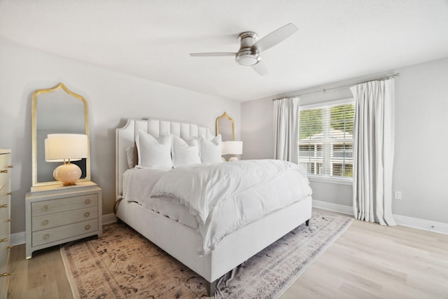 bedroom with ceiling fan, baseboards, and light wood-style flooring