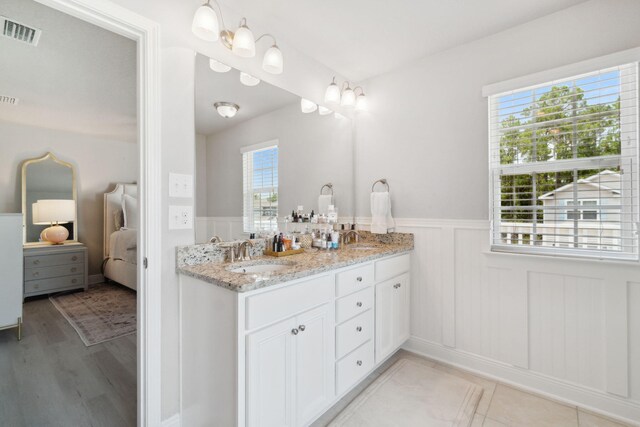 full bath with double vanity, visible vents, connected bathroom, and a sink